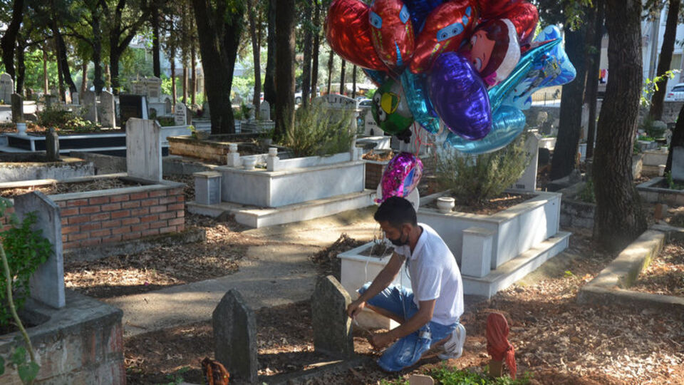 Çocuk mezarlarını gezip balon bağladı