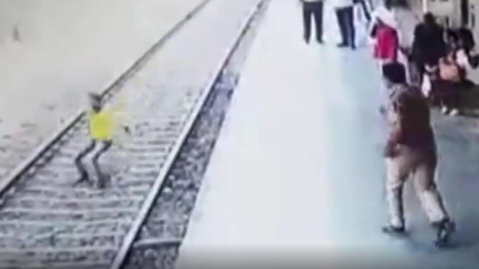 Hindistan'da polis raylara atlayan genci son anda kurtardı