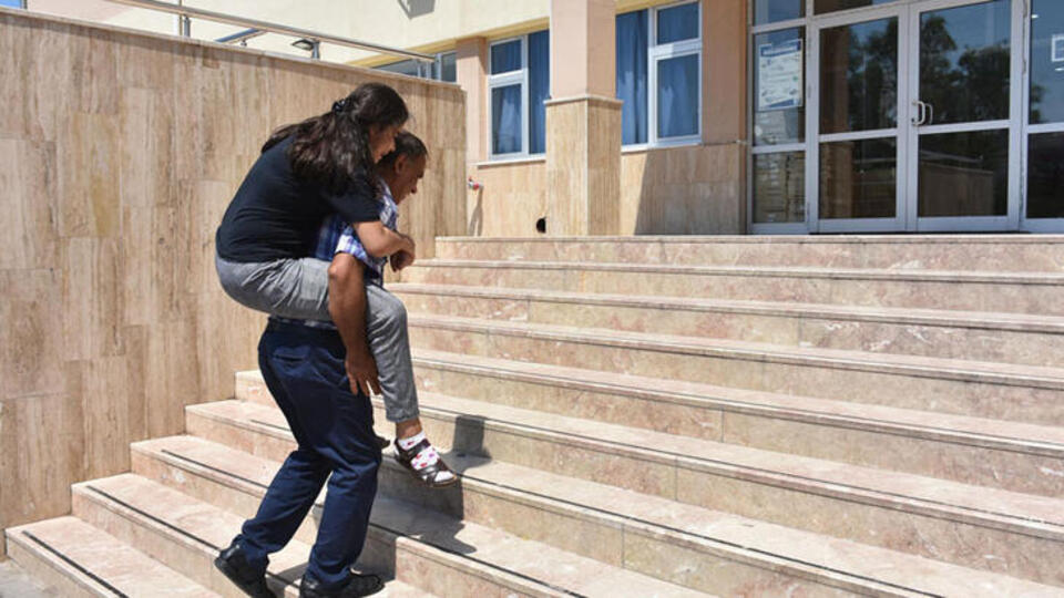Otizmli kızını her gün sırtında sınıfına taşıdı