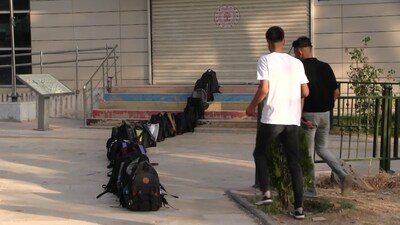 Kütüphaneye girebilmek için çantalarıyla sıra oluşturdular