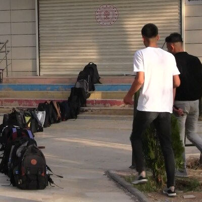 Kütüphaneye girebilmek için çantalarıyla sıra oluşturdular