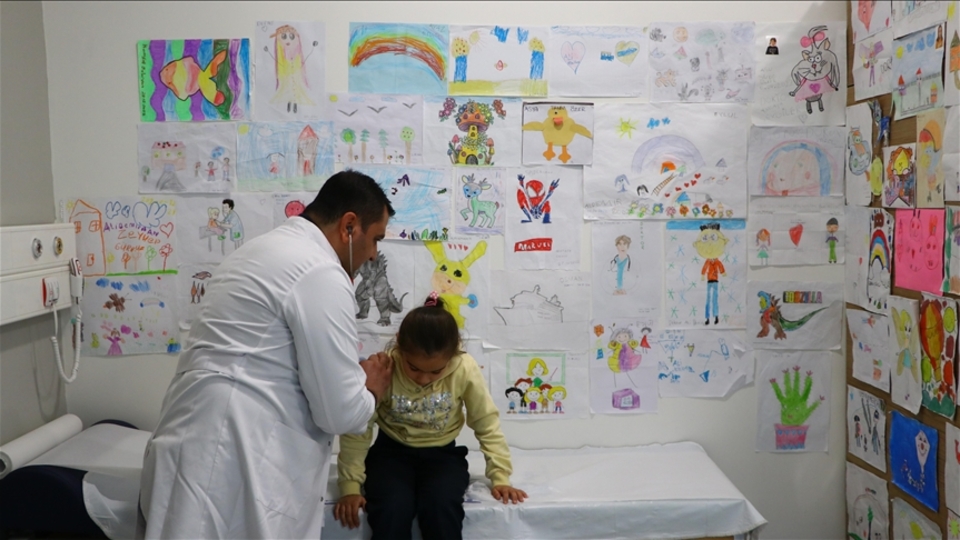 Tedavi ettiği çocukların çizdiği resimler hastanedeki odasının duvarlarını süslüyor