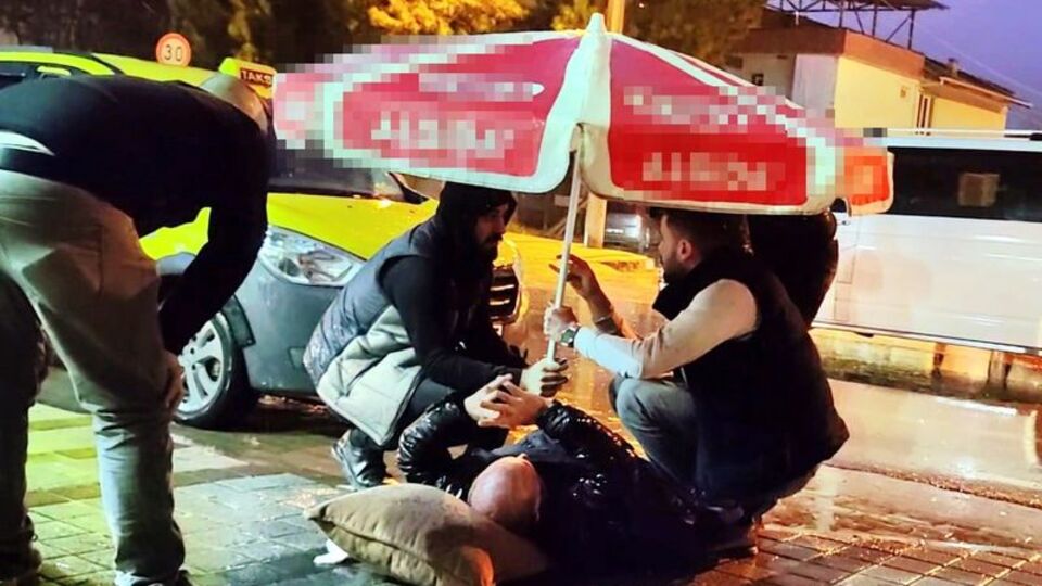 Yaralı yayaya şemsiye tuttu