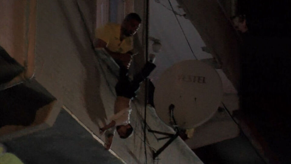 Korku dolu anlar! Çocuğunu rehin alıp camdan aşağı sarkıttı