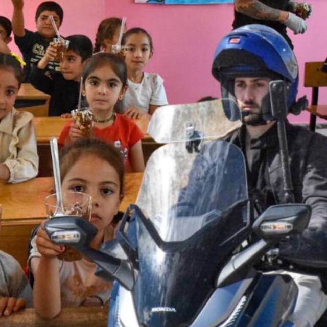 Motosikletiyle gidip, çocuklara tatlı ikram ediyor