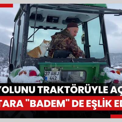 Kapanan köy yolunu traktörüyle açan muhtara "Badem" de eşlik ediyor