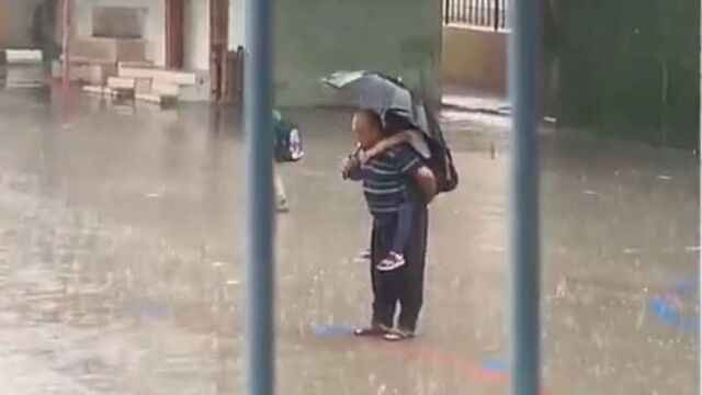 Yağmurda, sırtında torunu! İstiklal Marşı okudu