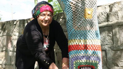 Bahçesindeki ağaçları örgü ile süsledi