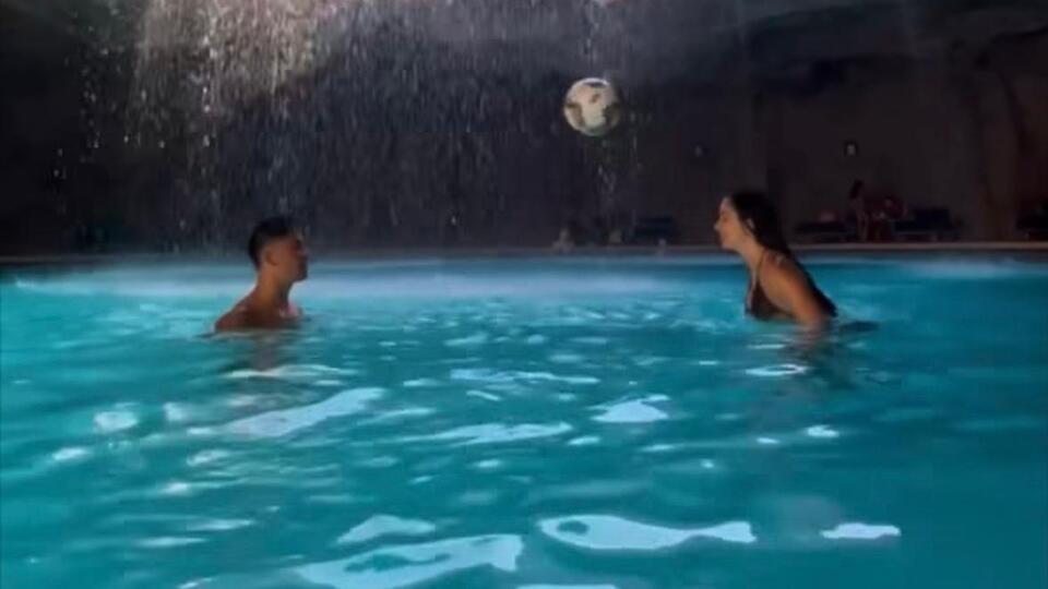 Sevgilisiyle havuzda top oynadı