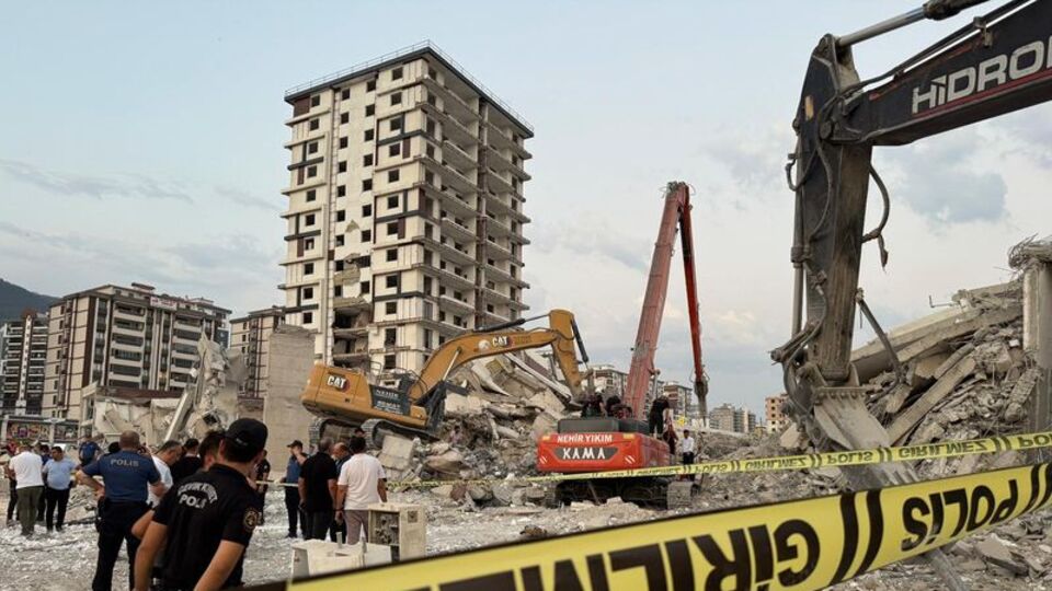 Ağır hasarlı bina iş makinesinin üzerine devrildi