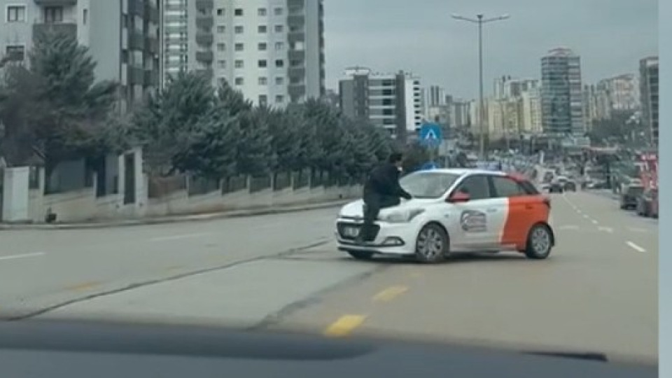 Aracın kaputunda sürükledi