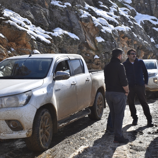 Bitlis'te elektrik arıza ekibinin çamura saplanan aracı iş makinesiyle çıka...