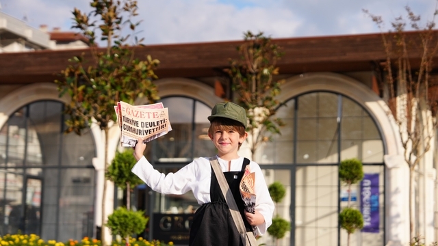 Dönemin kıyafetlerini giyen çocuk, 'Cumhuriyet'in ilanını yazıyor' diyerek gazete dağıttı