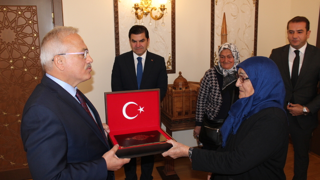 Aksaray Valisi'nden iş yeri önündeki bayrağı öpen bastonlu kadına hediye