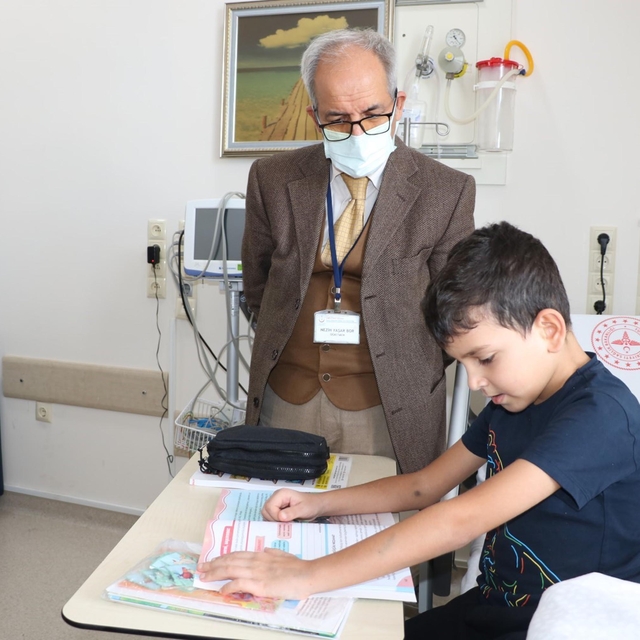 Nezih öğretmen, yatılı tedavi gören çocukların başucunda ders işliyor