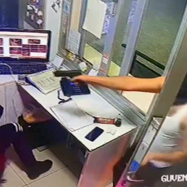 Maskeli ve silahlı şüphelinin güvenlik görevlisini rehin aldığı anların kam...