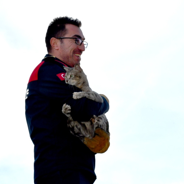 Mahsur kaldığı ağaçtan kurtardığı kedi, itfaiyecinin kucağından inmedi