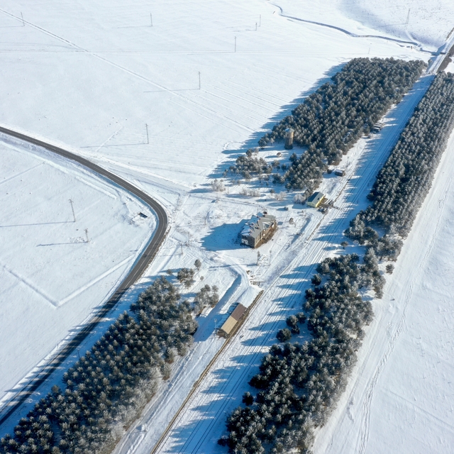 Çevresi ağaçlarla çevrili, karla kaplanmış tren istasyonu dronla görüntülen...