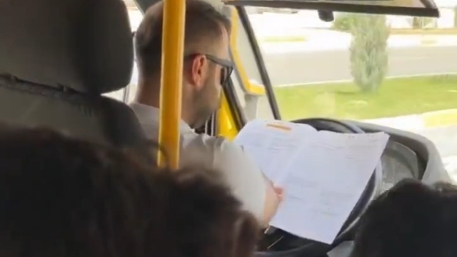 Minibüs şoförü, direksiyonda kitap okurken görüntülendi