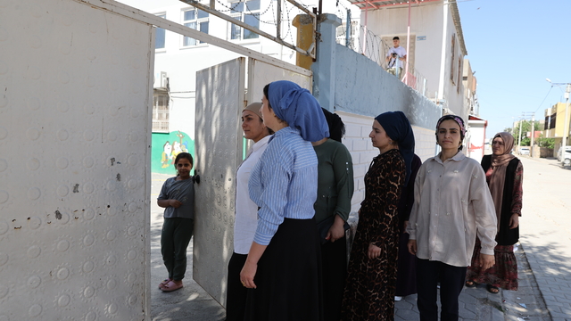 Kitap okuma yarışmasına katılan anneler çocuklarının oturduğu sıralarda sınava girdi