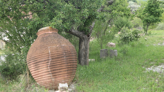 Köydeki kültürevinin bahçesini eski küp ve steller süslüyor