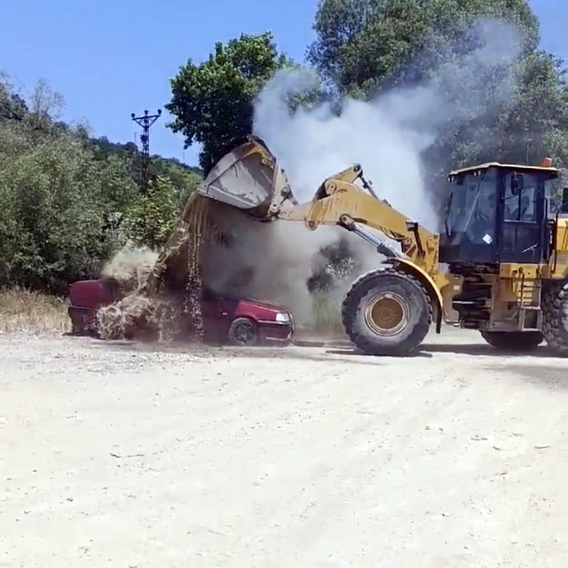 Park halindeyken alev alan otomobildeki yangın, iş makinesiyle dökülen suyl...