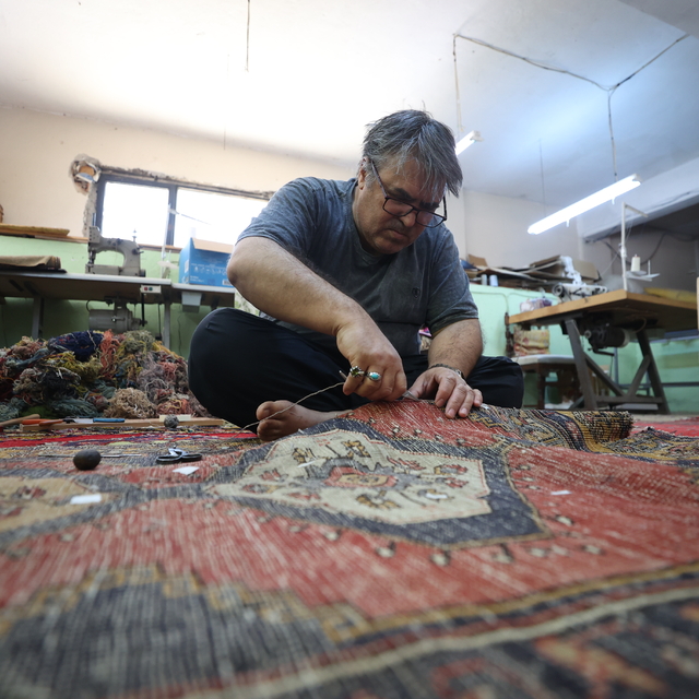 Halıları cerrah titizliğiyle onarıyor