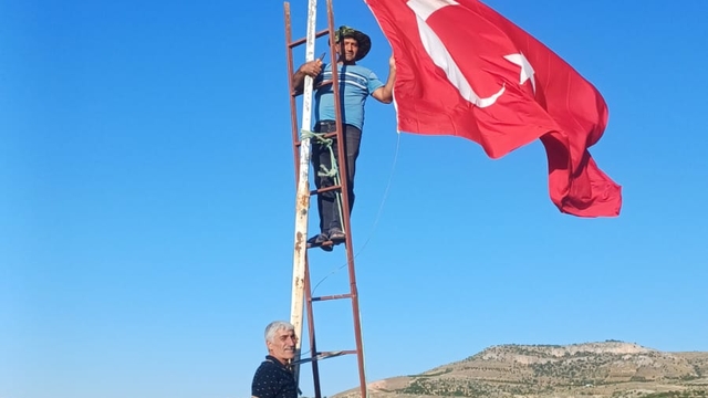 Muhtarı olduğu köyün en yüksek tepesine Türk bayrağı dikti
