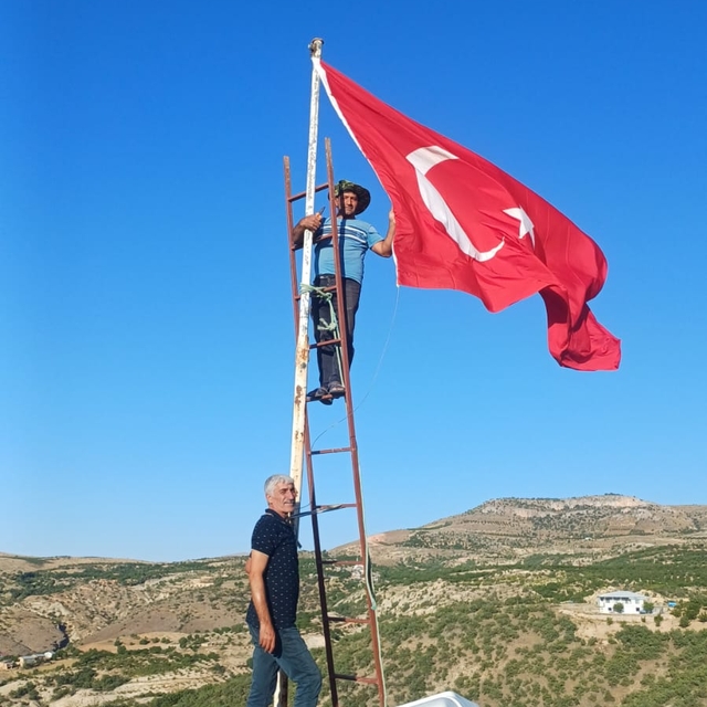 Muhtarı olduğu köyün en yüksek tepesine Türk bayrağı dikti