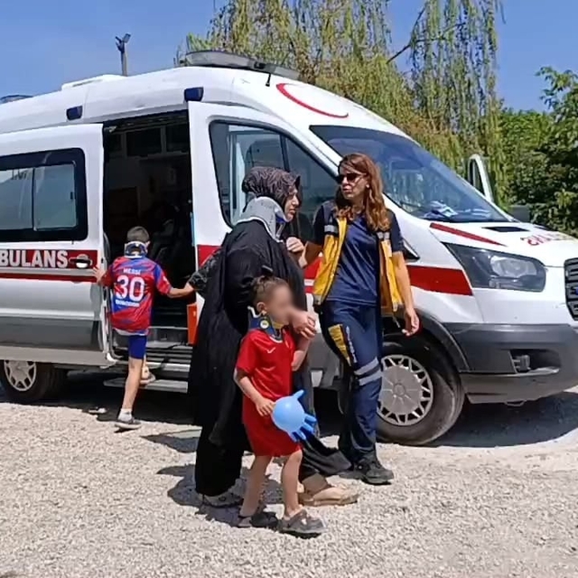 Sağlıkçılar, yaralı çocukları muayene eldiveninden yaptıkları balonla sakin...