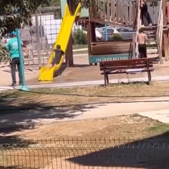 Sıcak havada parkta oynayan çocukları hortumla su sıkarak serinletti