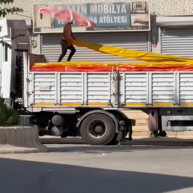 Kavurucu sıcakta beline bağladığı büyük boy şemsiye ile çalıştı