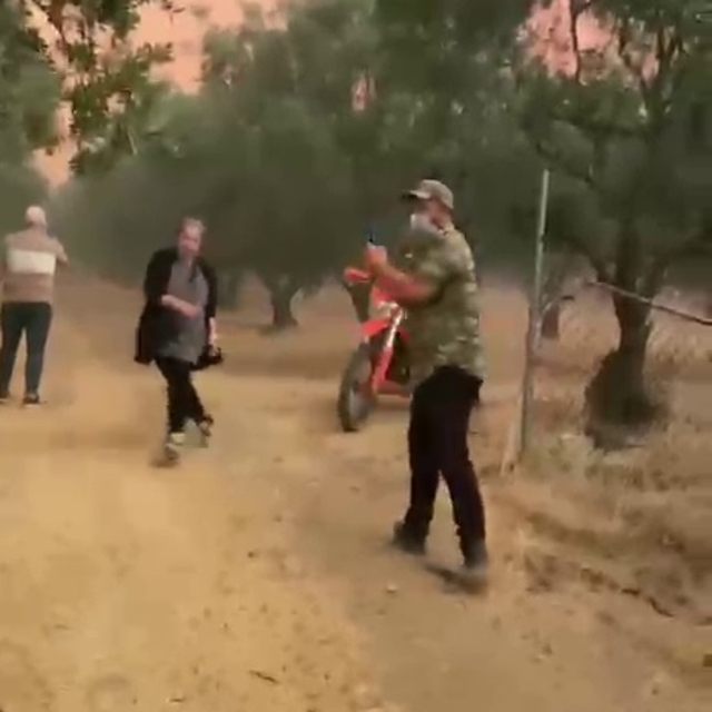 Belediye ekipleri, yangının tehdit ettiği evdeki aileyi tahliye ederken ale...