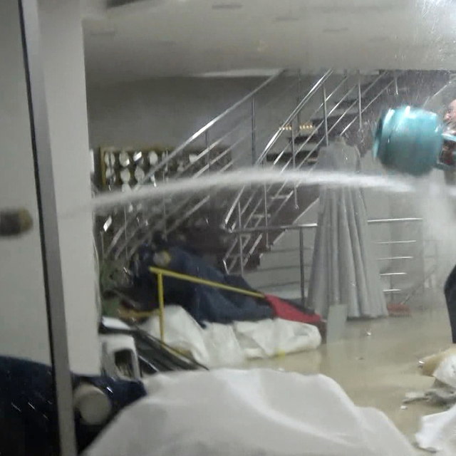 Dükkanındaki gelinlikleri yakmaya çalışan iş yeri sahibine tazyikli suyla m...