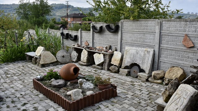 Tarihi yapılardaki motif ve simgeleri işlediği taşları bahçesinde sergiliyor