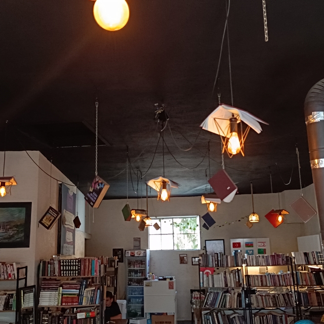 Kitapları, dijital çağa yenilmesine dikkat çekmek için kafenin tavanına ast...