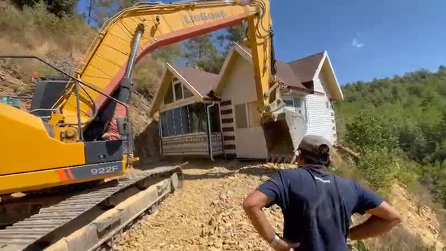 Yıkım kararı verilen konteyner evini iş makinesiyle karadan rayla yürütüp taşıdı