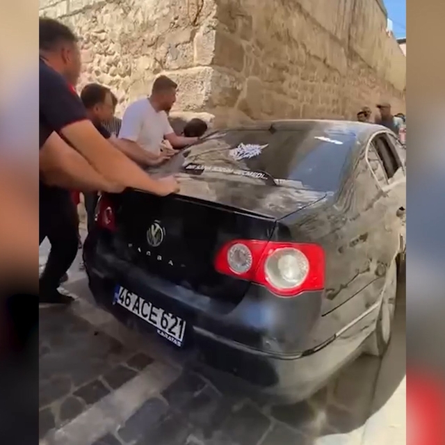 Dar sokakta sıkışan otomobil güçlükle çıkarıldı