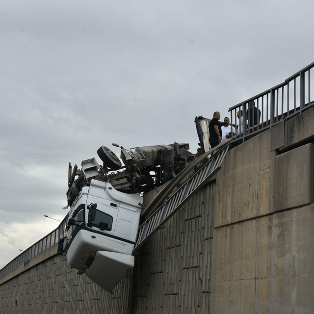 Devrilen TIR'ın kupası viyadükte asılı kaldı; şoförü yaralandı