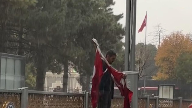 Erzincan'da yağmur altında yere düşen bayrakları topladı