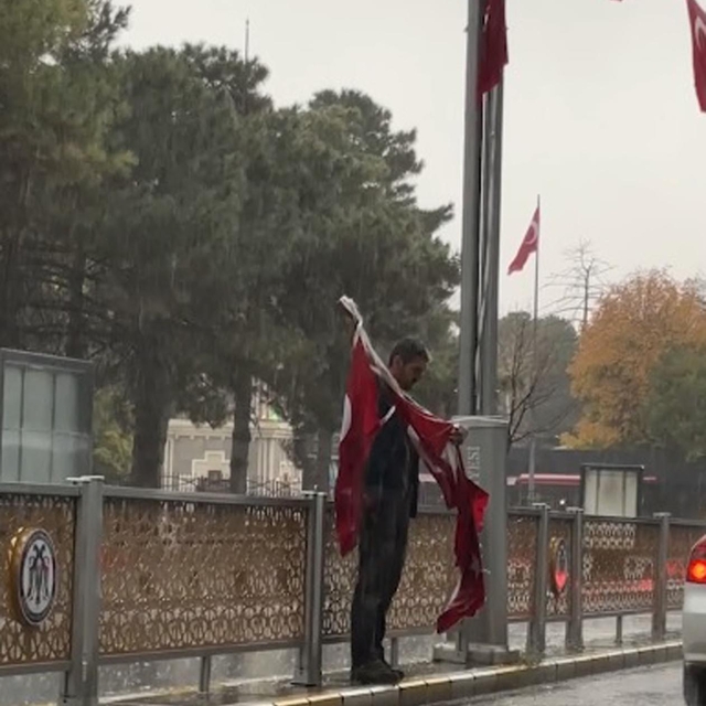 Erzincan'da yağmur altında yere düşen bayrakları topladı