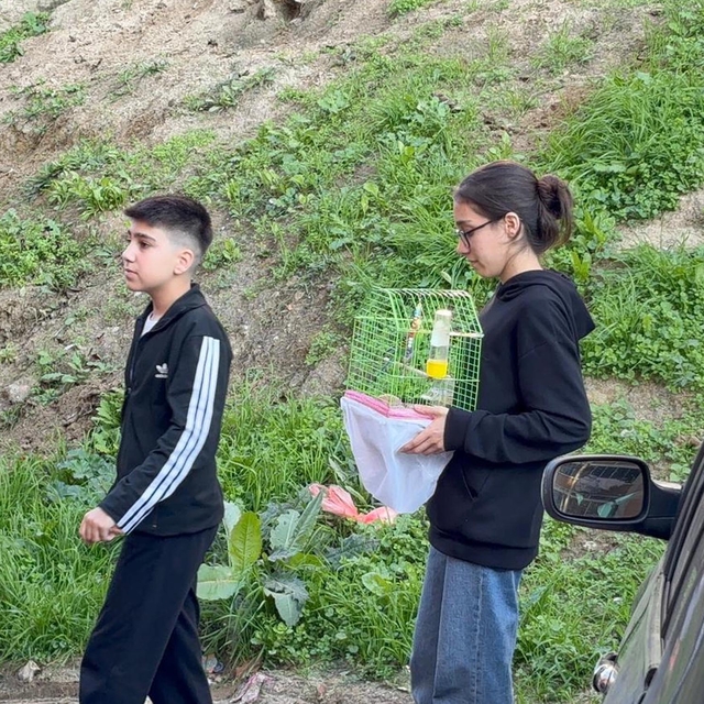 Yangında dumanın kapladığı apartmandaki evlerinden kafesteki kuşu ile çıktı