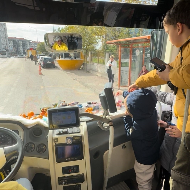 Şoför minibüse binen yolcularına meyve ve şekerleme ikram ediyor