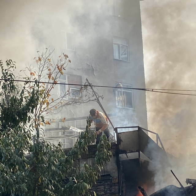 Depoda çıkan yangını kovayla su döküp söndürmeye çalıştı