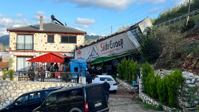 Antalya'da şarampole devrilen tırın bir eve çarparak durabildiği kazada sürücü yaralandı