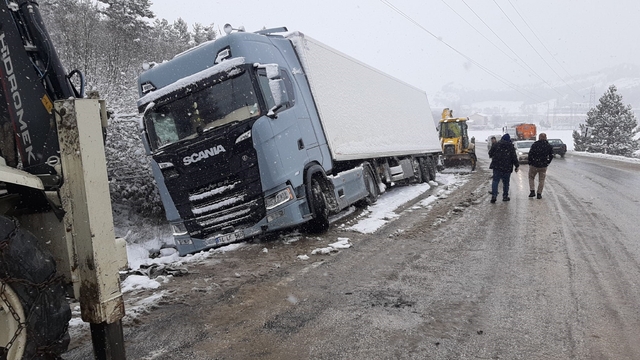 Karlı yolda, tır şarampole devrildi