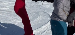 Kırmızı elbisesiyle Erciyes'te kayak yapıp, gül dağıttı