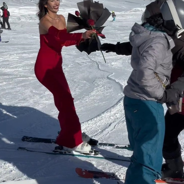 Kırmızı elbisesiyle Erciyes'te kayak yapıp, gül dağıttı