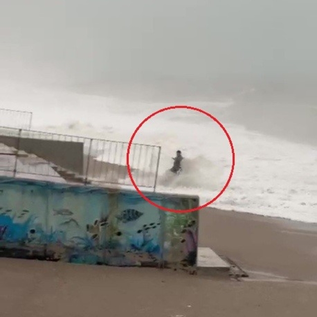 Son anda fark ettiği dev dalgaların arasında kalmaktan merdivene tutunarak...