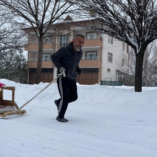 Torununu kızakla çekerek antrenman yapıyor